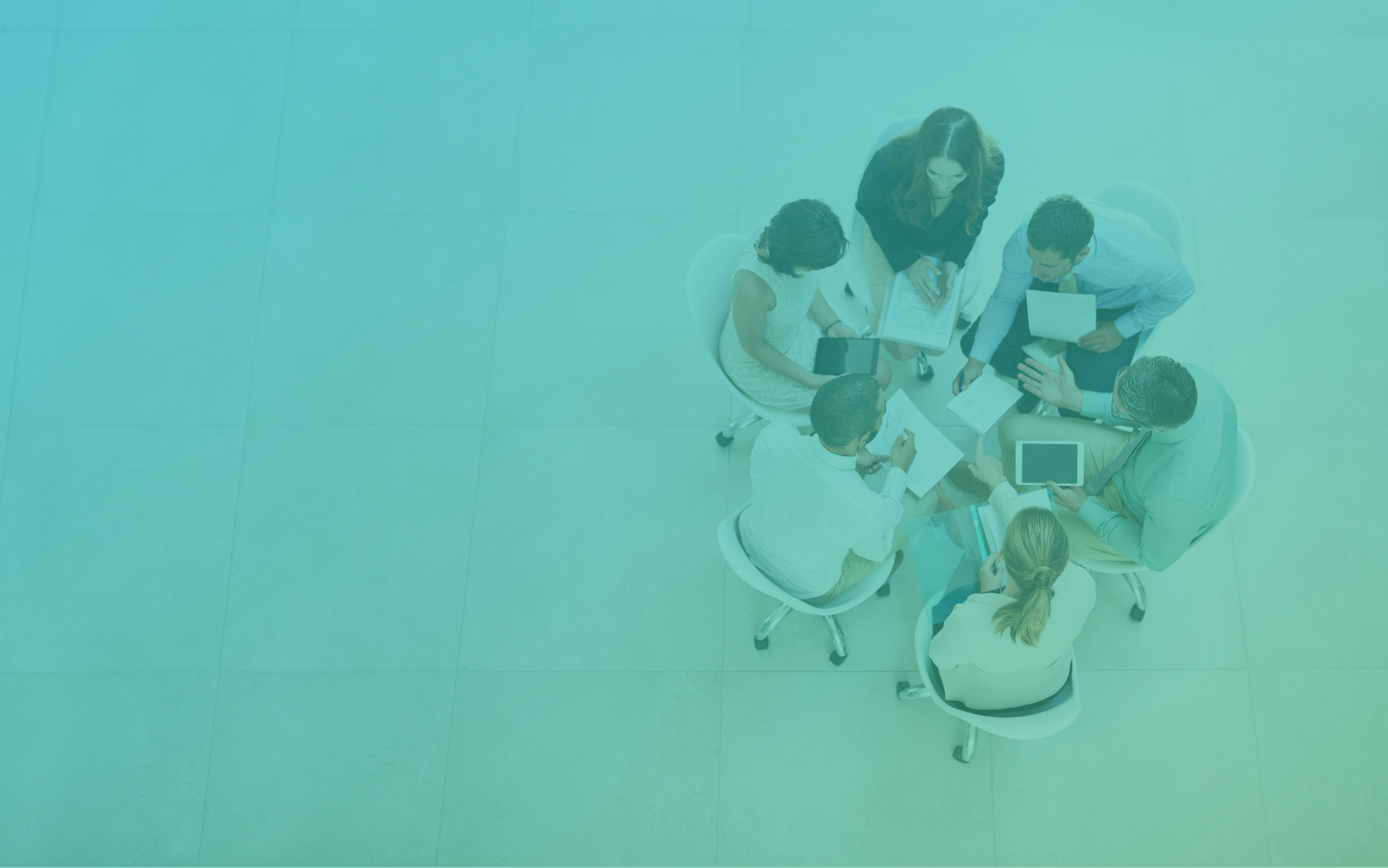 Aerial view of six people sitting in a circle reviewing a document.