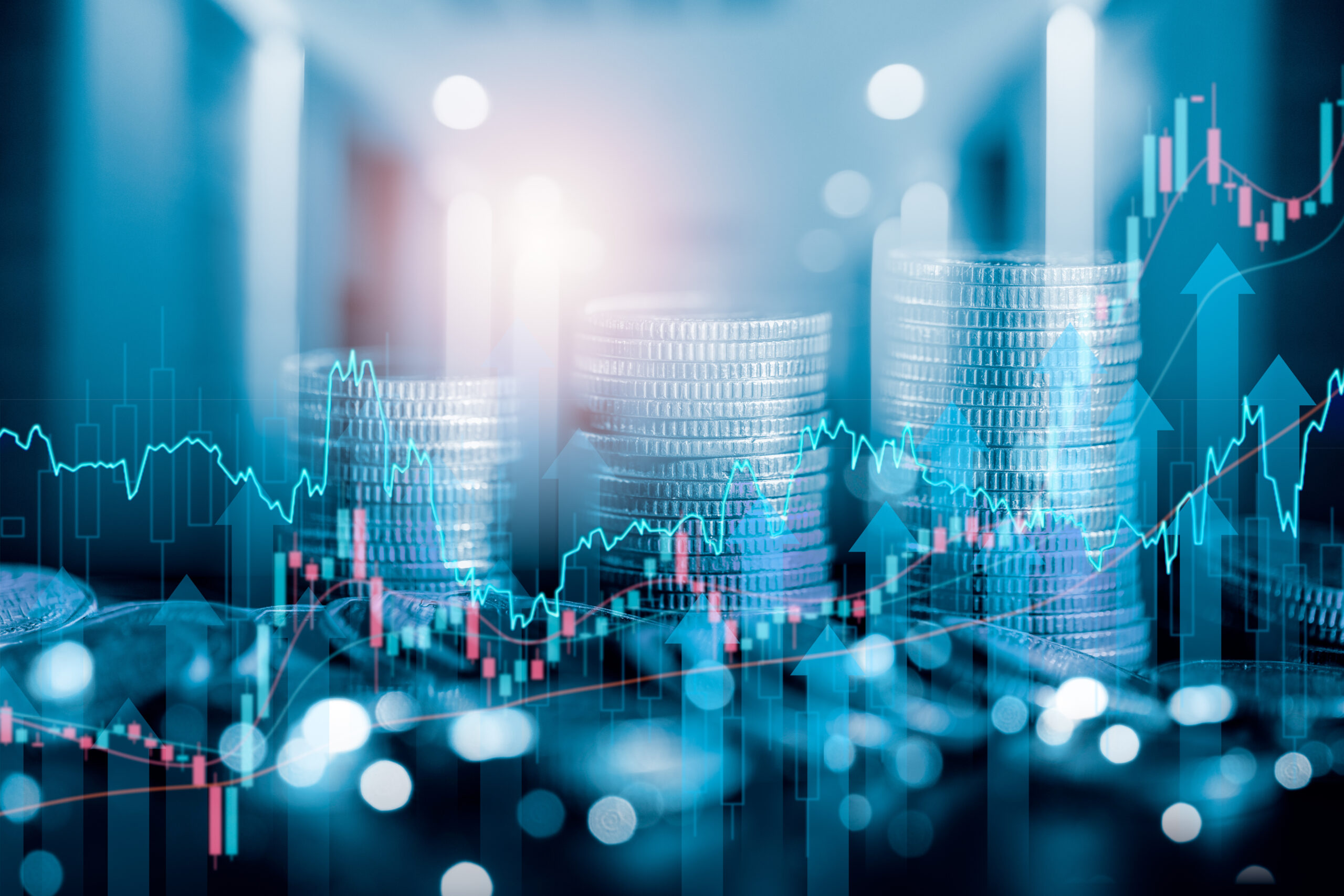 Three stacks of coins with graphs and digital elements superimposed over them.