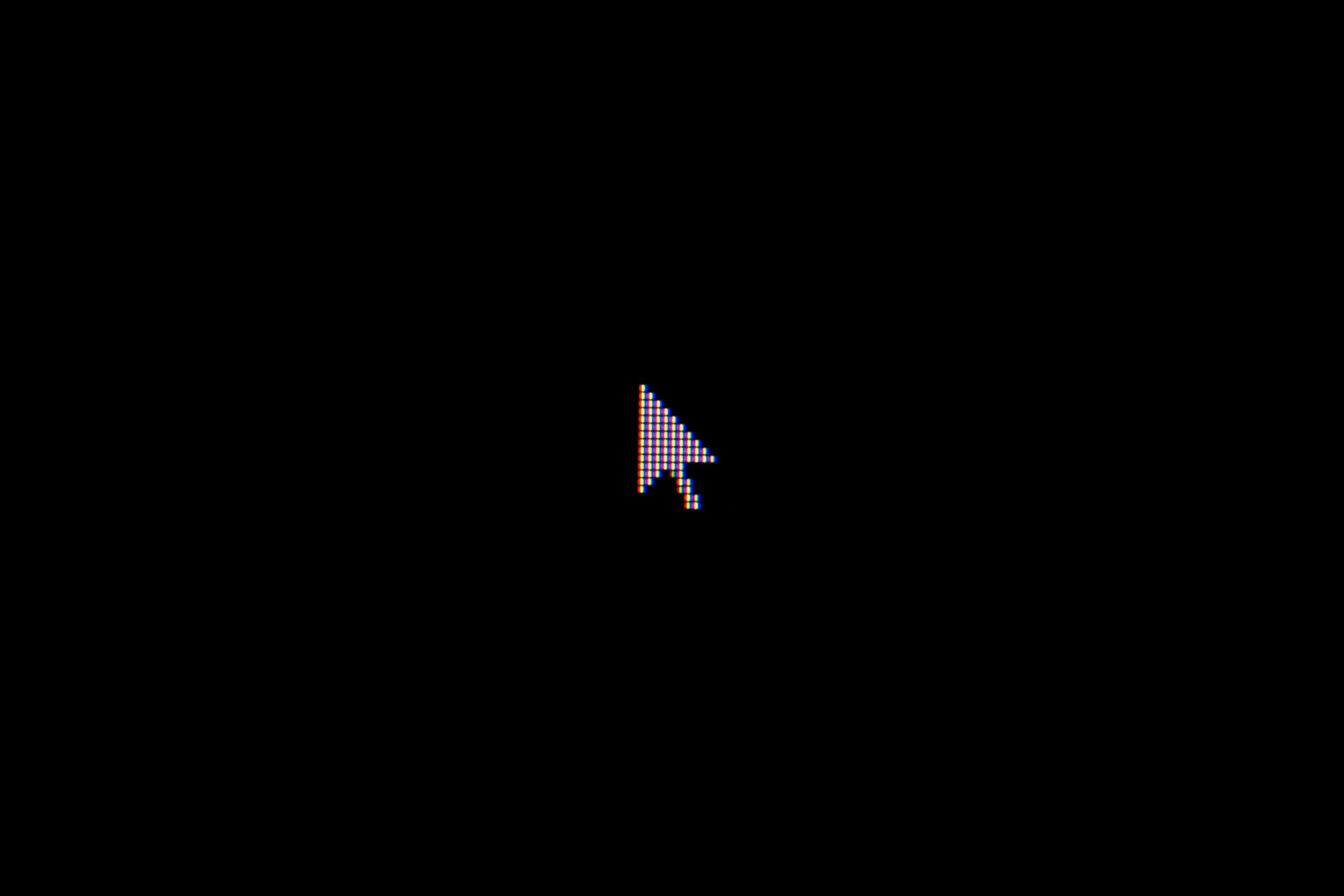 A zoomed in image of a cursor on a blank computer screen.